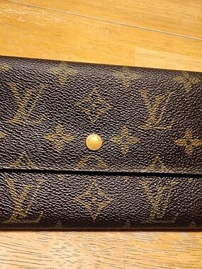 Louis Vuitton Sarah wallet features the iconic monogram canvas exterior
